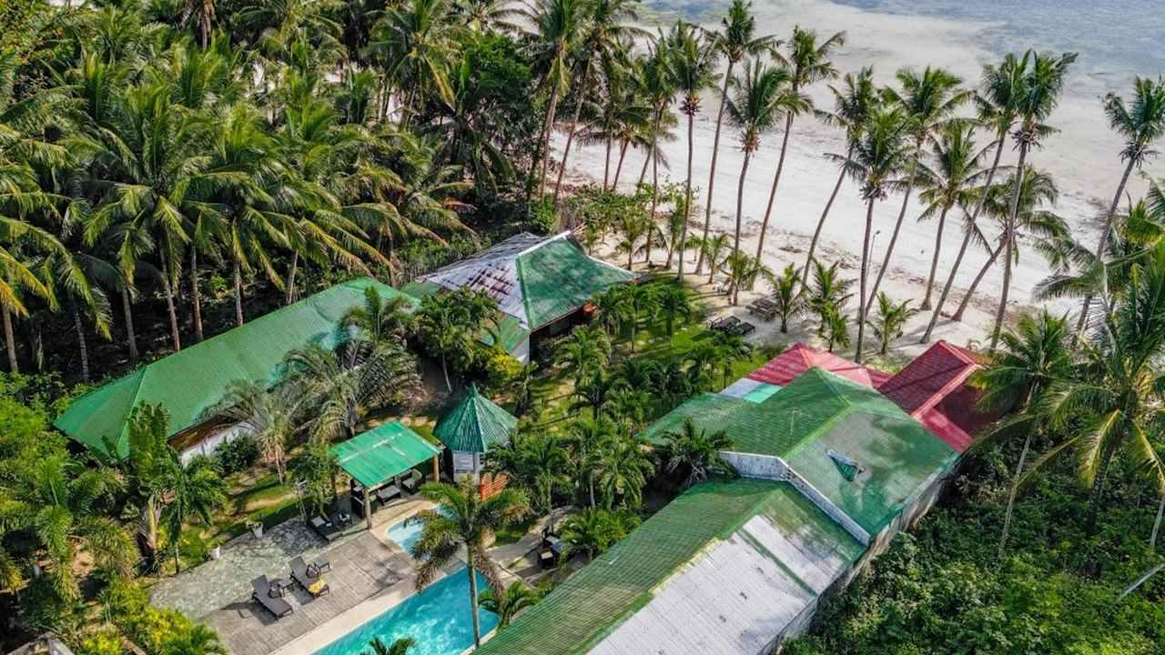 Illustration of a tropical island resort beside turquoise coastal waters at sunset in Siquijor